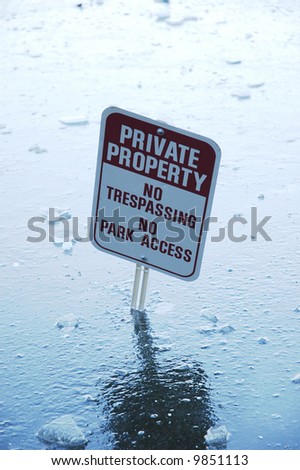 Private property sign misplaced in the ice covered lake