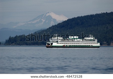 Ferry sailing through Puget sound with Mt. Baker on a background