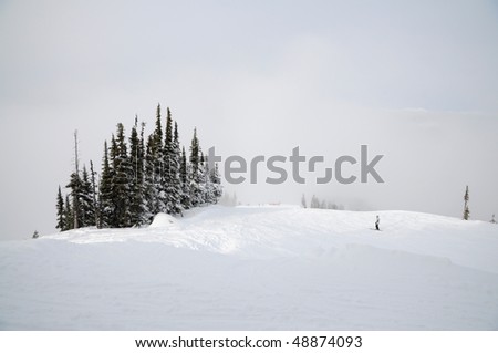 Solitary skier gliding up the slope on a cloudy hill