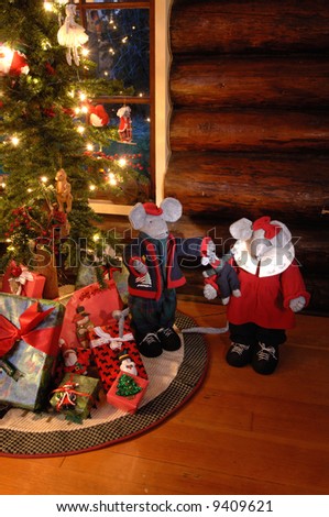 Christmas mice by an old fashioned looking christmas tree in log cabin