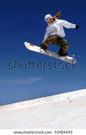 Woman snowboarder in mid-air with blue sky