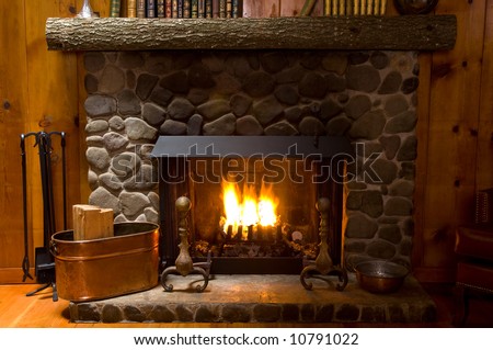 rock fireplace in a mountain cabin with fire cropped to just show fireplace natural lighting
