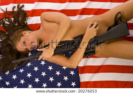 sexy nude woman covering herself with a M16 rifle lying on an American flag