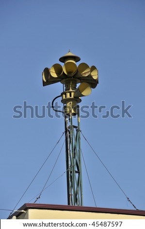 Emergency siren on a blue sky with guy wires for support
