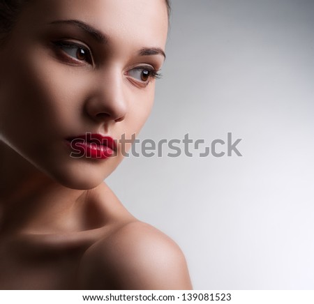 The beautiful girl with the clean face posing in studio on gray background