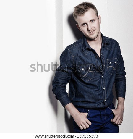 portrait of the handsome young man in jeans clothes on a white background