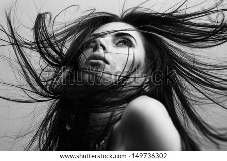 Portrait of a beautiful fashionable young girl with flying hair