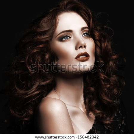 portrait of the beautiful young girl with red hair on a black background in studio