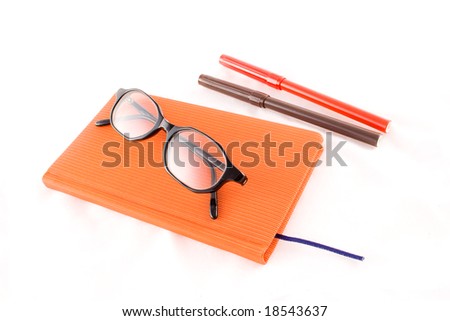 red book, black glasses and markers isolated on a white background