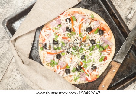 Homemade pizza on baking tray and Ingredients for cooking. From the series \