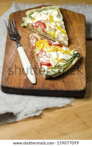 Two slices of vegetable pie on wooden cutting board. From series \