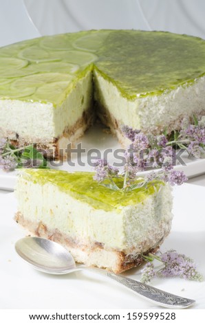 Lime cheesecake decorated with mint flowers. From series \