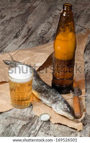 Two dry fish with beer on wrapping paper From series Fun food