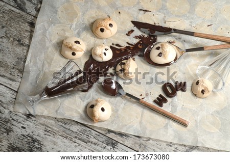 Funny meringue with chocolate, wineglass and spoon on baking paper. From series Fun food
