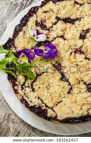 Crumble pie with black currants decorated with flower From series Summer desserts