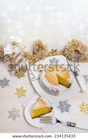 Festive pumpkin cake with coconut on table and Christmas decoration. Background bokeh. From series of Winter pastries