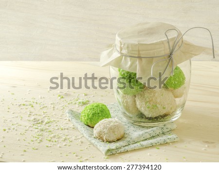 Sugar cookies with coconut flakes in glass jar. Near napkin