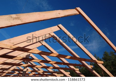 Wood Roof Trusses viewed from inside of new home looking out to a blue sky above .Ukraine