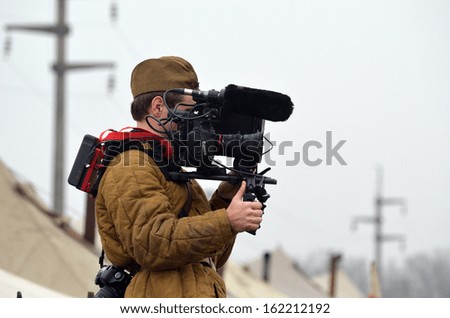 KIEV, UKRAINE -NOV 3 Estonian TV cameraman wears historical Soviet uniform working during historical reenactment of WWII, Battle for Kiev 1943 on November 3, 2013 in Kiev, Ukraine