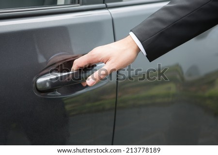 Close-up  hand of  man in formal wear opening a car door