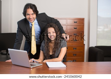 Executives working on computer and looking at camera