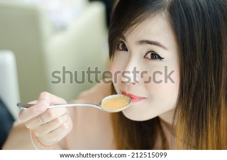 Hungry woman holding a soup spoon ,in restaurant