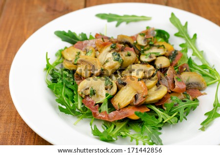Appetizer with fresh rocket salad, smoked ham and fried mushrooms