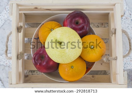 fruits, orange, apple and golden pear in wooden crate isolate on white