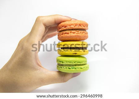 Colorful macaroon stack and hand isolated on white background