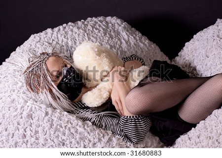 Lying girl with white hear and teddy bear