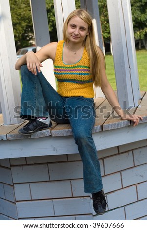 Portrait of the girl in yellow top sitting on wood construction