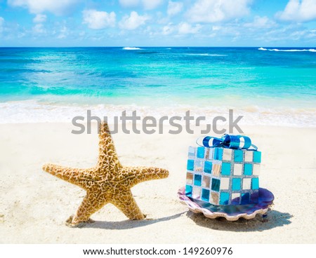 Starfish and seashell with Christmas decoration on sandy beach in sunny day- holiday concept