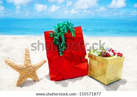 Starfish with gift box and bag on sandy beach in sunny day- holiday concept
