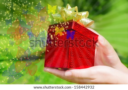 Gift box in woman's hands on green phone with butterfly and stars