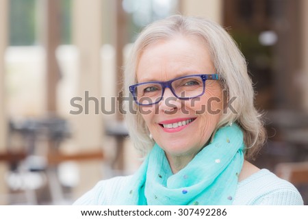 Smiling pretty blonde middle aged woman at outdoors cafe