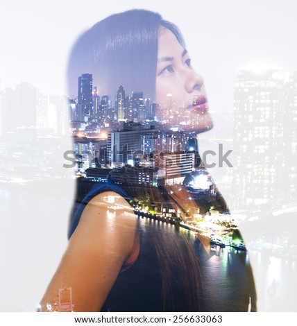 Double exposure portrait of an Asian working woman thinking about big city at night.