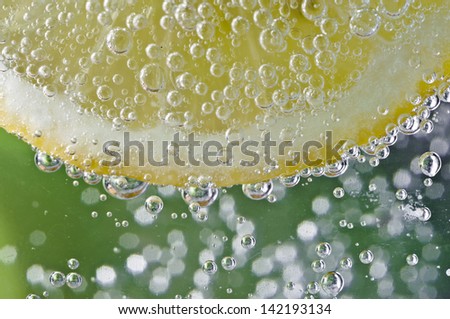 Lemon slice in carbonated drink with bubbles