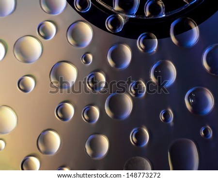 Compact Disk with water drops on it with vibrant colors closeup