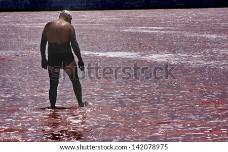 Man covered in mud about to bathe in a salt lake near Torrevieja,Alicante province,Spain