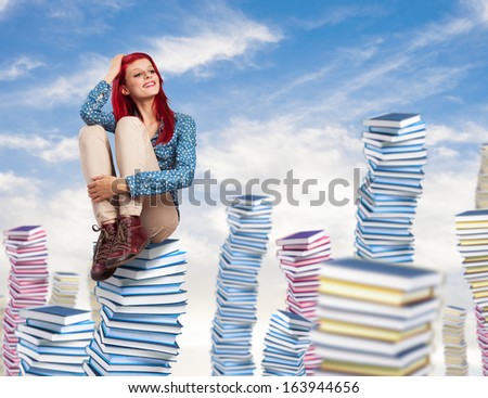 young pretty woman thinking and sitting on a big books pile