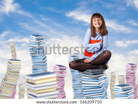 young woman hugging a book sitting on a books pile
