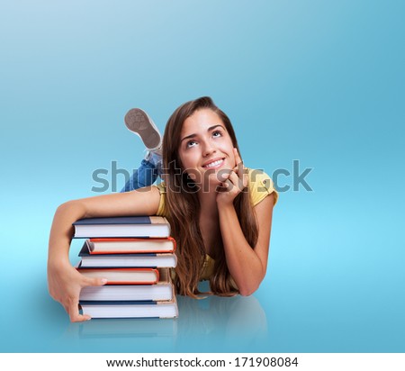 young woman lying hugging a books pile
