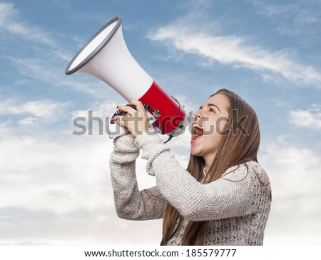 Angry young woman shouting with a megaphone