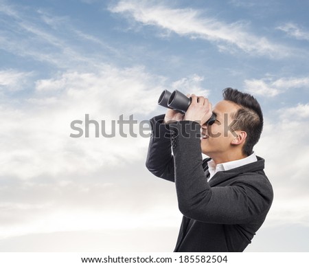handsome young asian man looking trough a binoculars