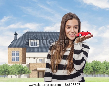 Beautiful young woman holding a red car