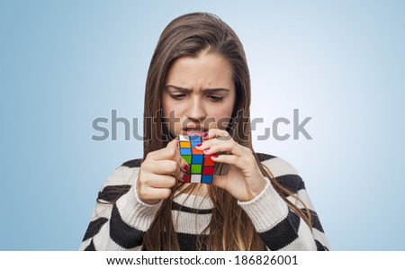 beautiful young woman concentrated solving the Rubik\'s Cube