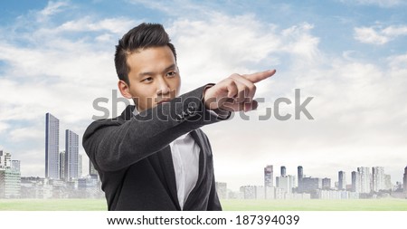 Handsome young business asian man pointing up