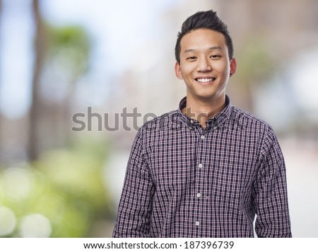Handsome young asian man smiling wearing a plaid shirt