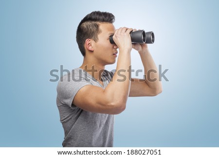 handsome young asian man looking through a binoculars