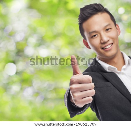handsome young asian man with thumb up